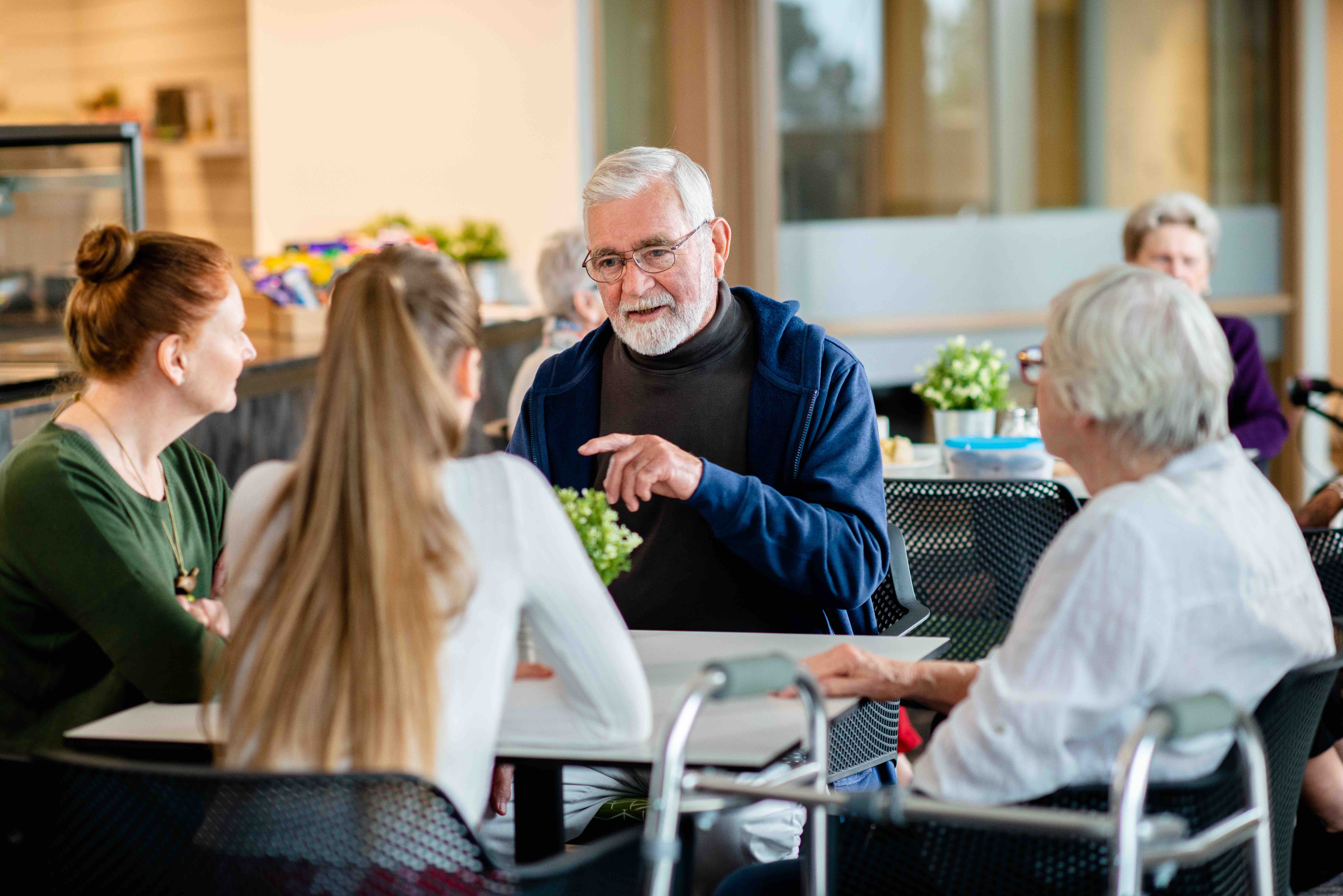 A man and woman sit with their granddaughter at a cafe table