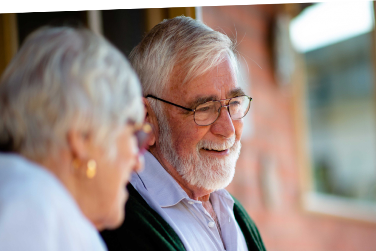 An older man and woman smiling at each other