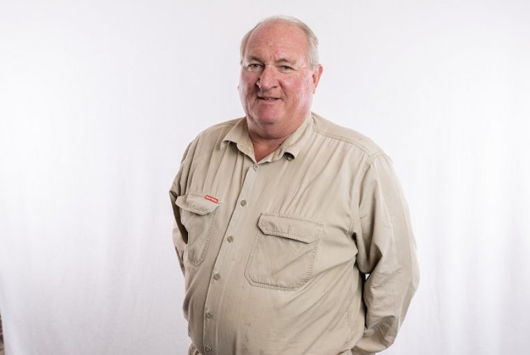 A male maintenance officer smiles at the camera