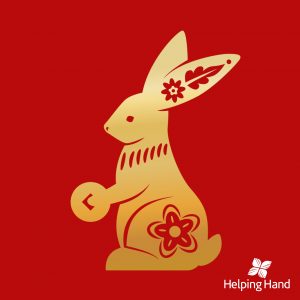 Lunar new year illustration of a gold rabbit on a red background with Helping Hand logo in the bottom right corner