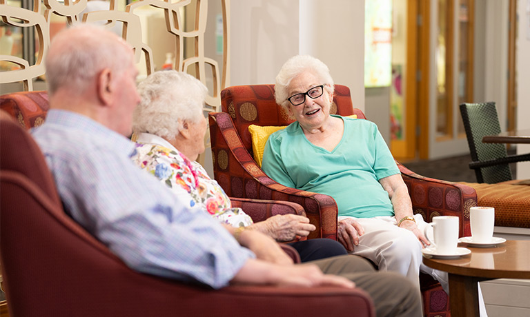 Group of elderly people chatting on armchairs