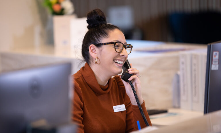 Female reception staff member on phone call respite care