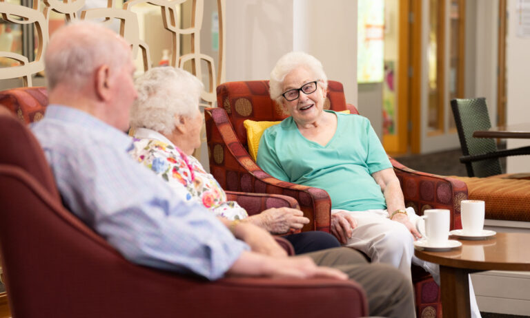 Group of three in lounge chairs having a chat