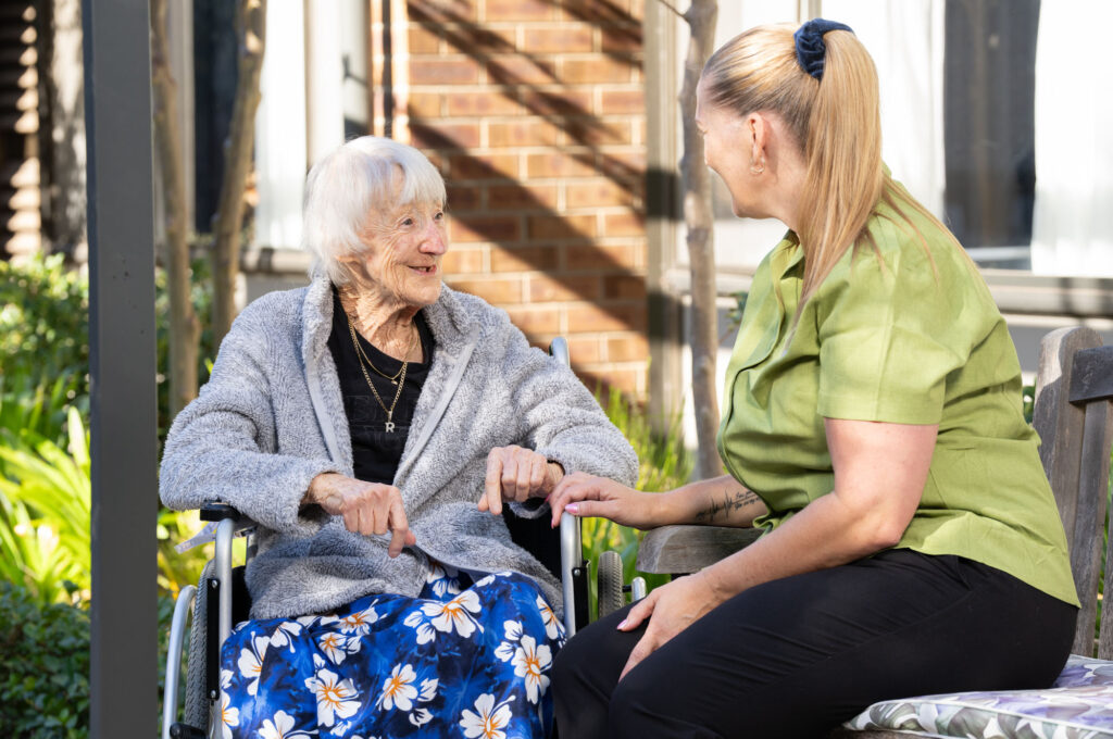 Helping Hand worker sitting with elderly woman